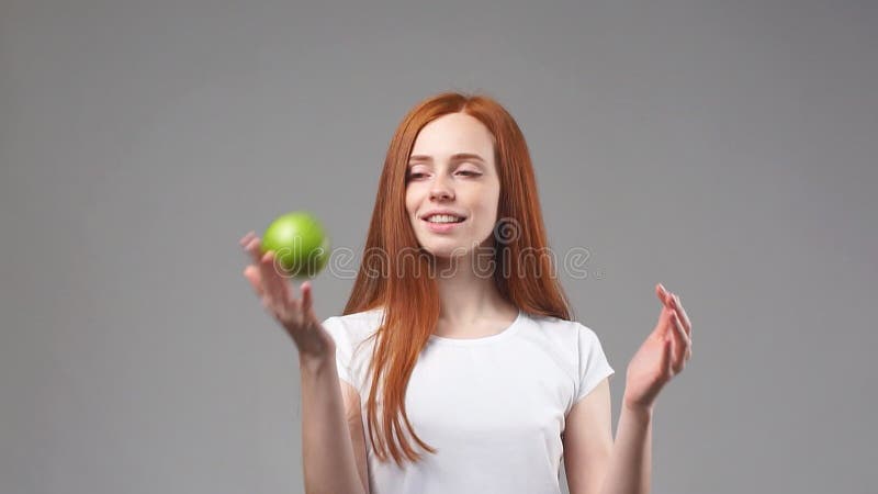 Молодая девушка redhead мечет зеленое Яблоко движение медленное сток-видео