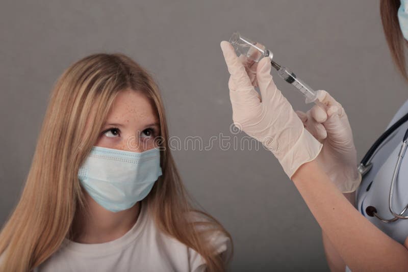 молодая девушка пришла, чтобы получить вакцину. доктор набирает инъекцию. covid19 стоковое фото