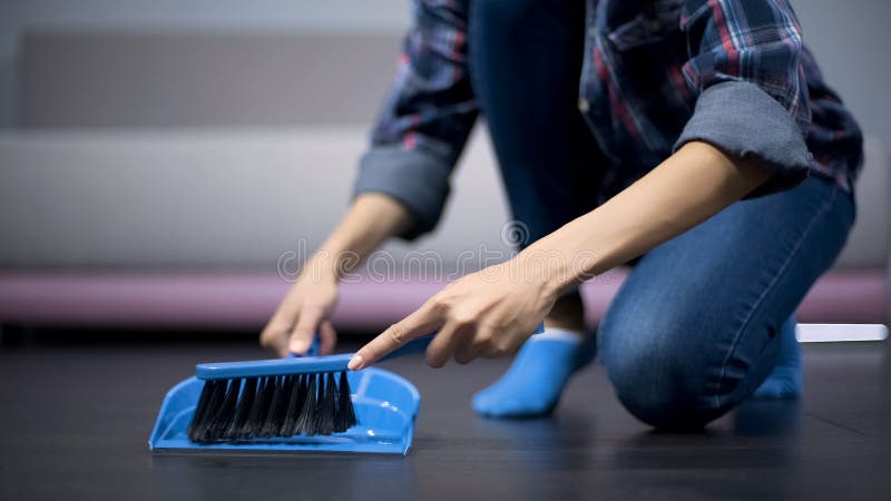 Молодая домохозяйка очищая незапятнанный пол с щеткой и dustpan, большой гигиеной стоковая фотография Молодая домохозяйка очищая незапятнанный пол с щеткой и dustpan, большой гигиеной стоковая фотография