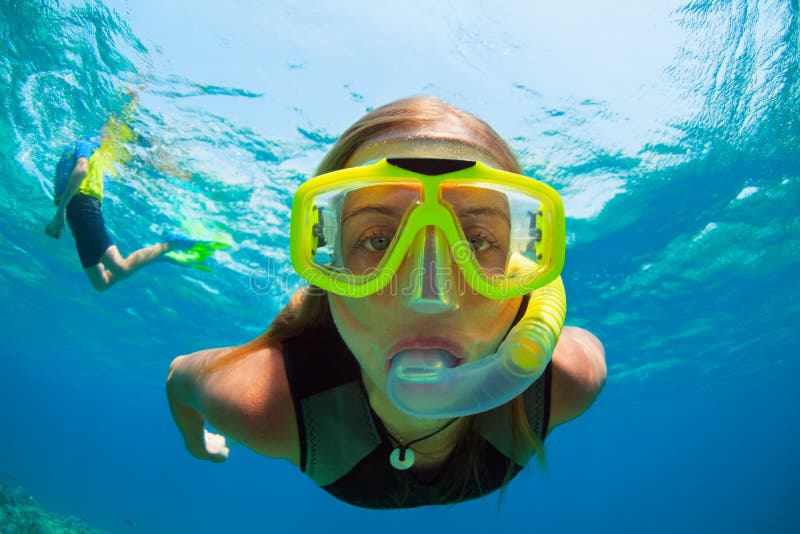 Молодая женщина snorkeling с рыбами кораллового рифа стоковая фотография Молодая женщина snorkeling с рыбами кораллового рифа стоковая фотография