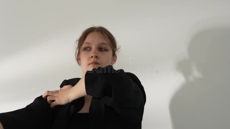 Молодая женщина в черной одежде, танцующая современник на белом фоне сток-видео