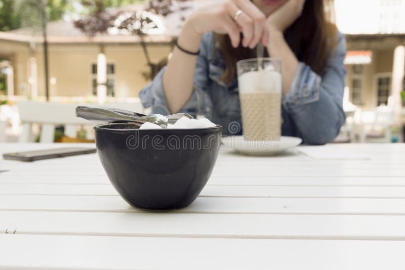 Молодая женщина наслаждаясь ее latte на кофейне Отдых, holi стоковая фотография rf Молодая женщина наслаждаясь ее latte на кофейне Отдых, holi стоковая фотография rf