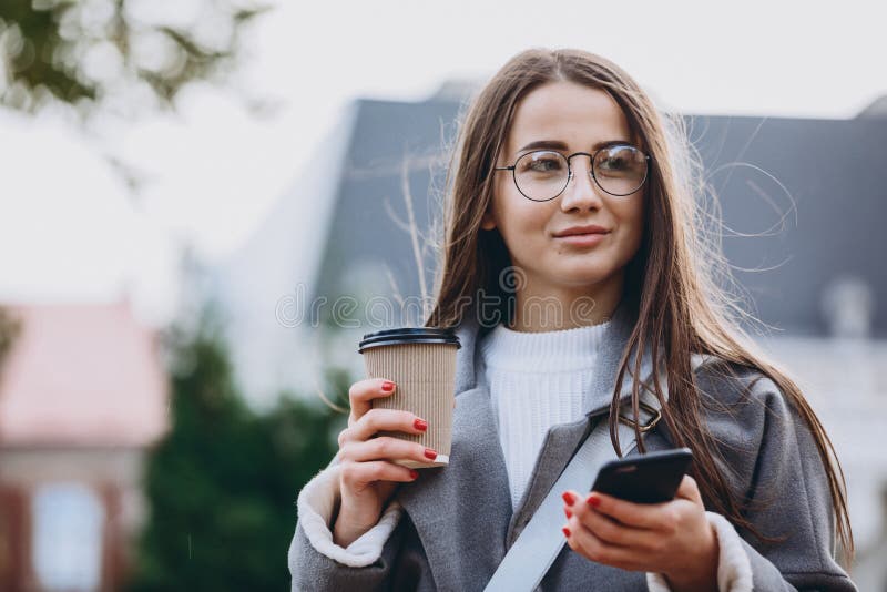 Молодая женщина отправляя SMS или используя смартфону стоковое фото rf Молодая женщина отправляя SMS или используя смартфону стоковое фото rf