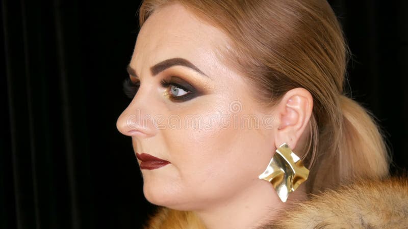 молодая женщина с ярким вечерним макияжем дымящиеся глаза и длинными ложными ресницами и темной помадой на губах поражает видеоматериал
