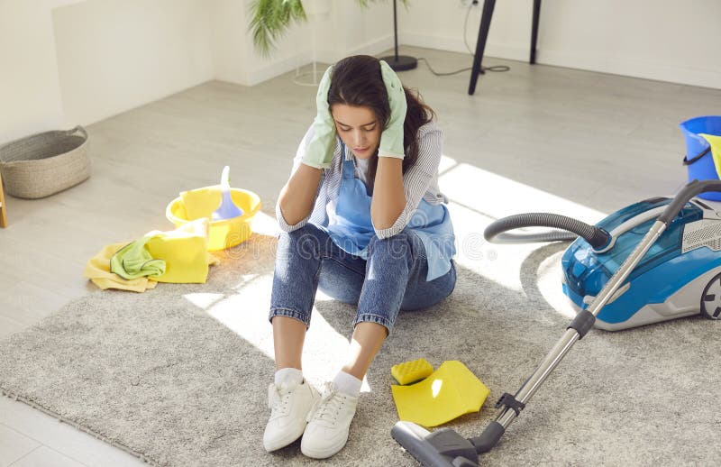 молодая женщина сидит на полу рядом с пылесосом устал делать работу по дому. стоковые изображения rf