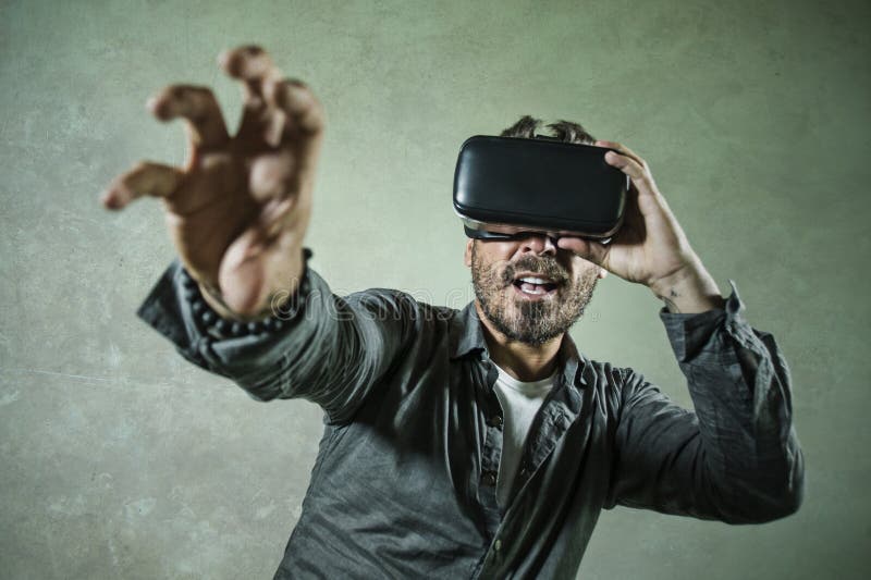 Молодая иллюзия 3d шлемофона изумленных взглядов виртуальной реальности VR счастливого и возбужденного человека нося эксперименти стоковая фотография rf Молодая иллюзия 3d шлемофона изумленных взглядов виртуальной реальности VR счастливого и возбужденного человека нося эксперименти стоковая фотография rf