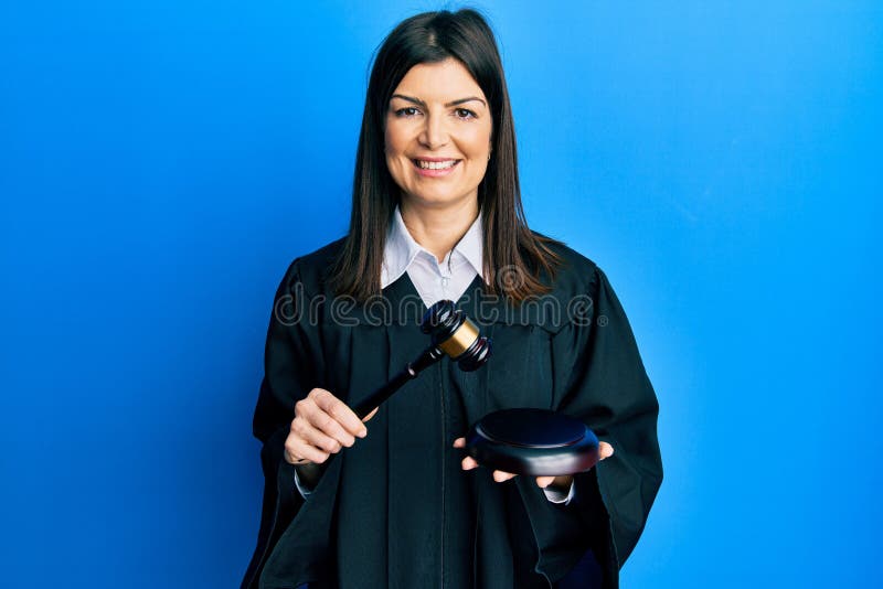 Young hispanic woman using gavel smiling with a happy and cool smile on face. showing teeth. Young hispanic woman using gavel smiling with a happy and cool smile on face. showing teeth