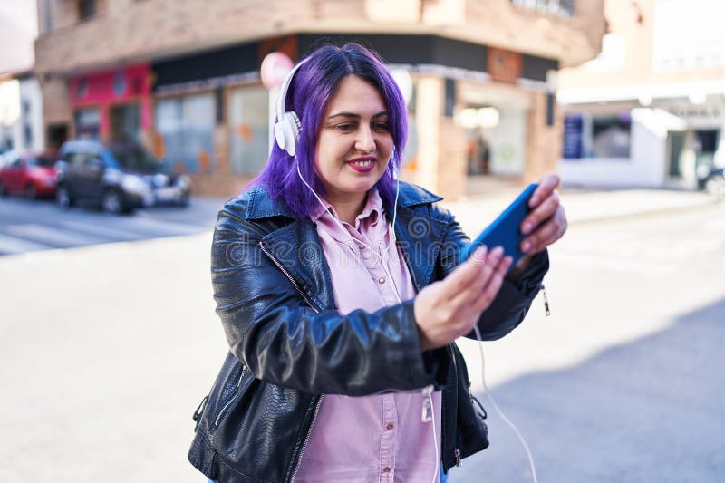 молодая красивая женщина plus size улыбается уверенно играя в видеоигру на улице стоковая фотография rf