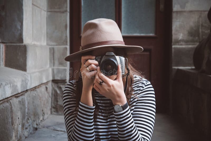 Молодая красивая женщина в шляпе фотографирует с старомодной камерой, outdoors стоковые фото Молодая красивая женщина в шляпе фотографирует с старомодной камерой, outdoors стоковые фото
