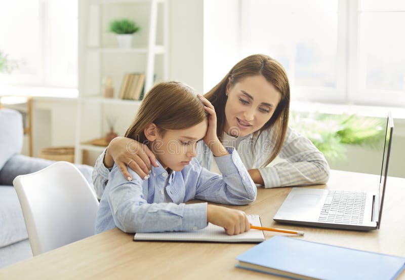 Молодая мама поддерживает своего маленького расстроенного мальчика устал делать школьные домашние задания. стоковая фотография