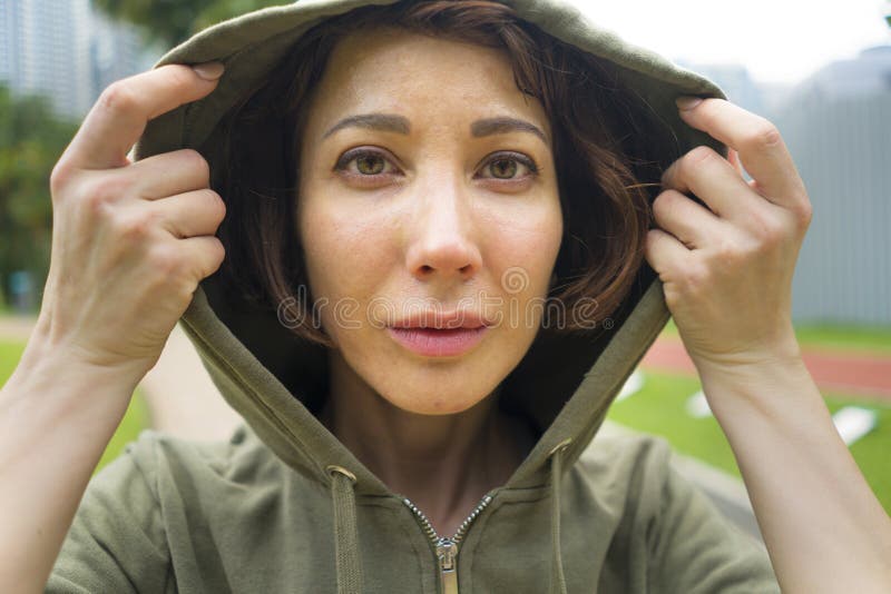 Молодая привлекательная и активная женщина jogger в верхней части hoodie готовой для разминки утра идущей на красивом парке город стоковые изображения Молодая привлекательная и активная женщина jogger в верхней части hoodie готовой для разминки утра идущей на красивом парке город стоковые изображения