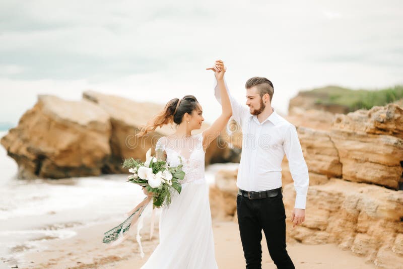 Молодой groom пар с невестой на песчаном пляже стоковое изображение