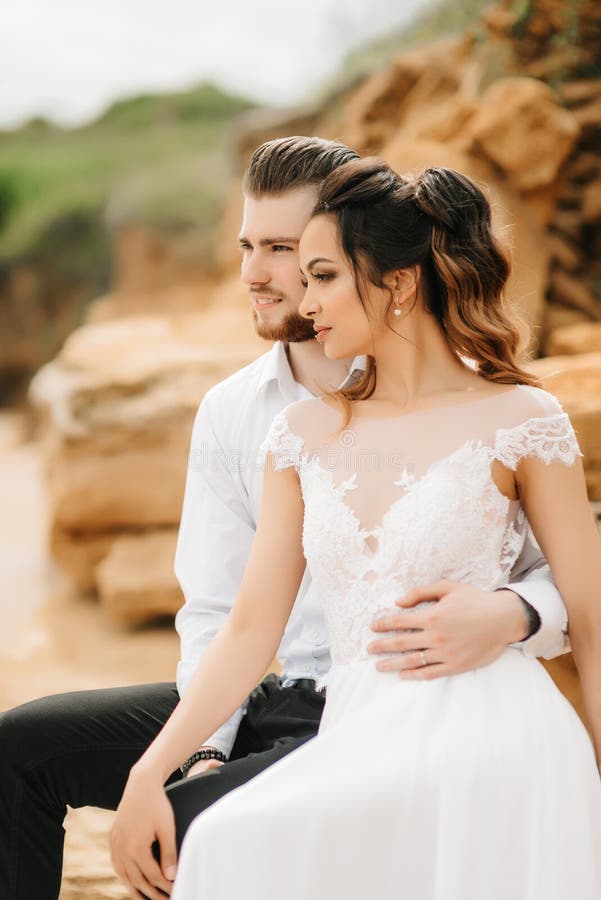 Молодой groom пар с невестой на песчаном пляже стоковое фото