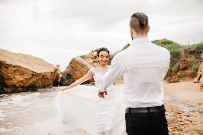 Молодой groom пар с невестой на песчаном пляже стоковые изображения