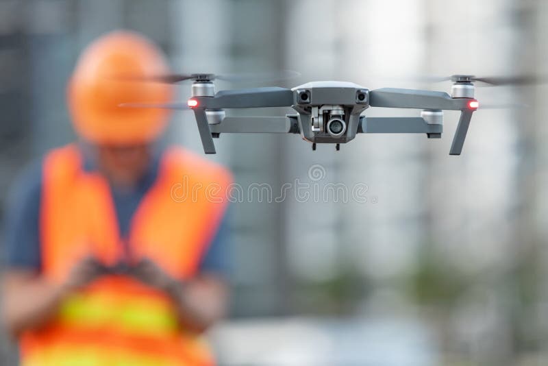 Young Asian engineer flying drone over construction site. Using unmanned aerial vehicle UAV for land and building site survey in civil engineering project. Young Asian engineer flying drone over construction site. Using unmanned aerial vehicle UAV for land and building site survey in civil engineering project.