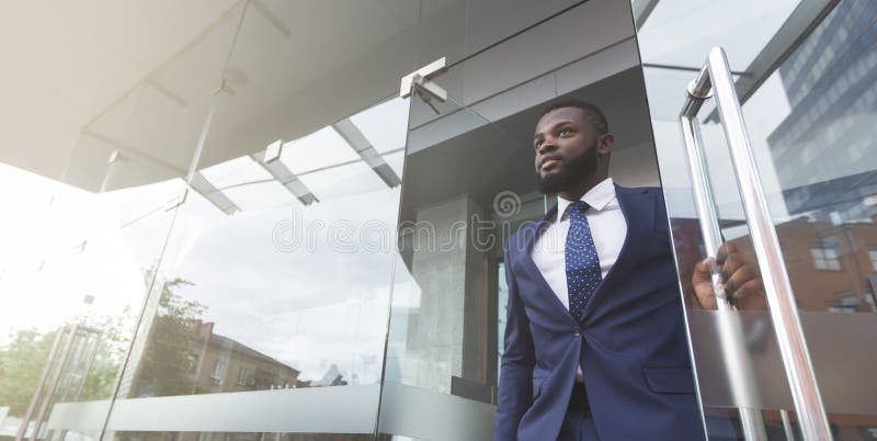 Молодой африканский соискатель работы выходит из здания после собеседования стоковые изображения rf