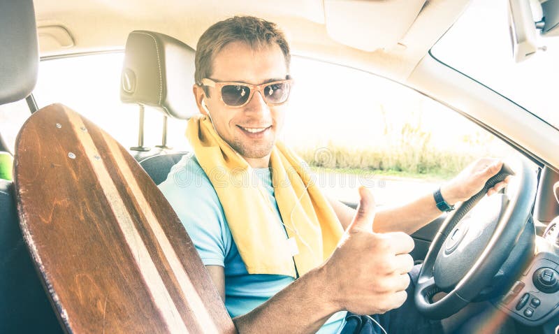 Молодой парень фотомодели битника управляя автомобилем с longoboard на s стоковое фото