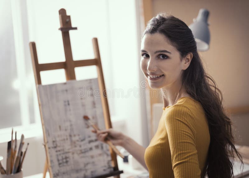 Молодой художник работая на абстрактной картине в atelier стоковое изображение Молодой художник работая на абстрактной картине в atelier стоковое изображение