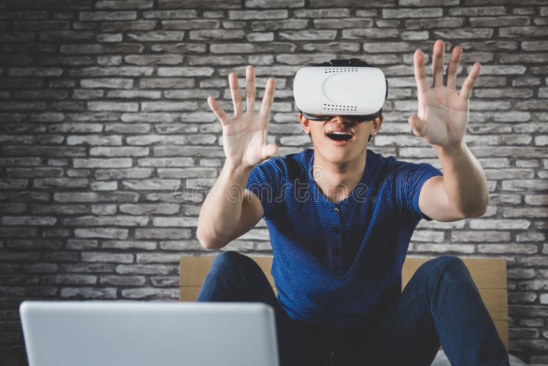 Молодой человек в шлемофоне виртуальной реальности или стеклах 3d играя видео стоковое изображение Молодой человек в шлемофоне виртуальной реальности или стеклах 3d играя видео стоковое изображение