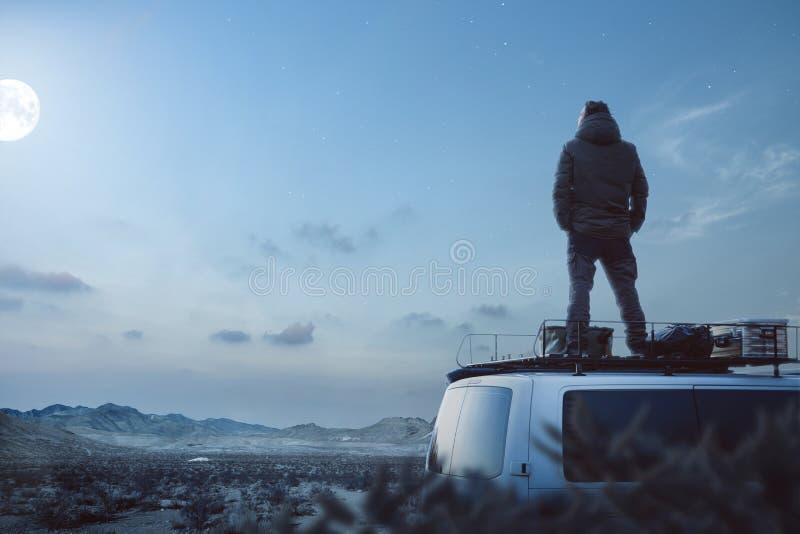 Молодой человек наслаждаясь залитой лунным светом ночью поверх его жилого фургона
