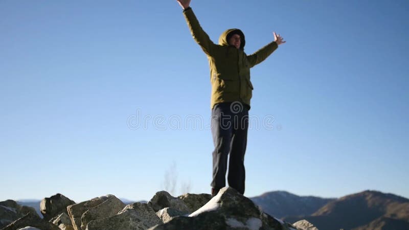 Молодой человек стоит na górze горы, наслаждающся свободой и красотой вокруг замедленное движение, 1920x1080, полное hd