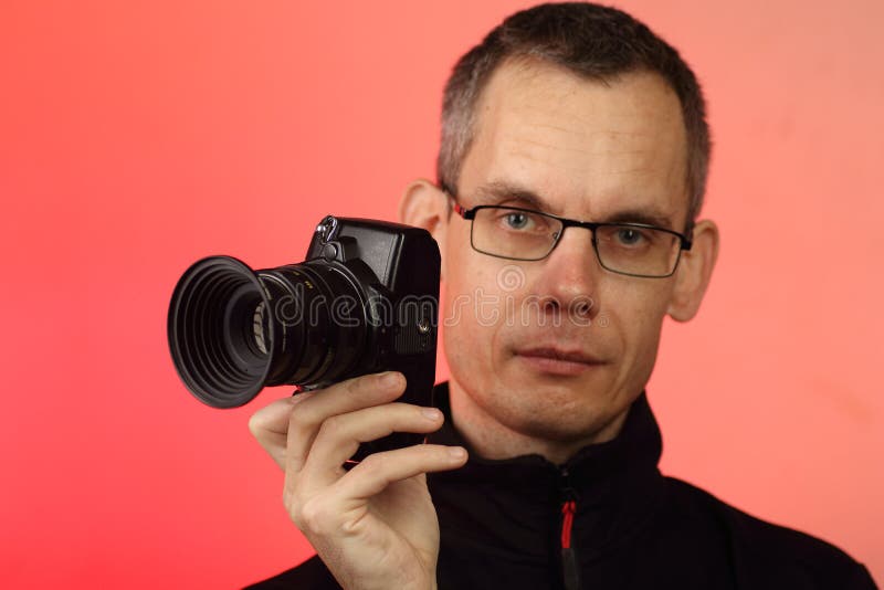 молодой человек фотографирует с помощью цифровой фотоаппарата со старыми линзами стоковое фото rf