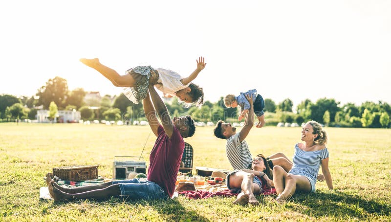 Молодые multiracial семьи имея потеху играя с детьми на партии барбекю nic pic - многокультурная концепция утехи и любов стоковое изображение rf Молодые multiracial семьи имея потеху играя с детьми на партии барбекю nic pic - многокультурная концепция утехи и любов стоковое изображение rf