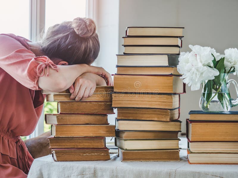Молодые красивые женщины и стек винтажных книг стоковые изображения