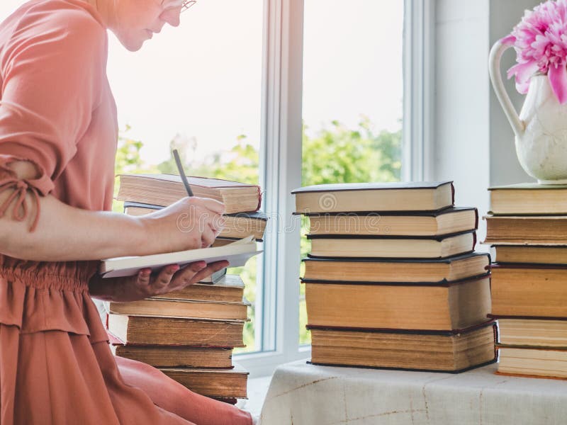 Молодые красивые женщины и стек винтажных книг стоковые изображения