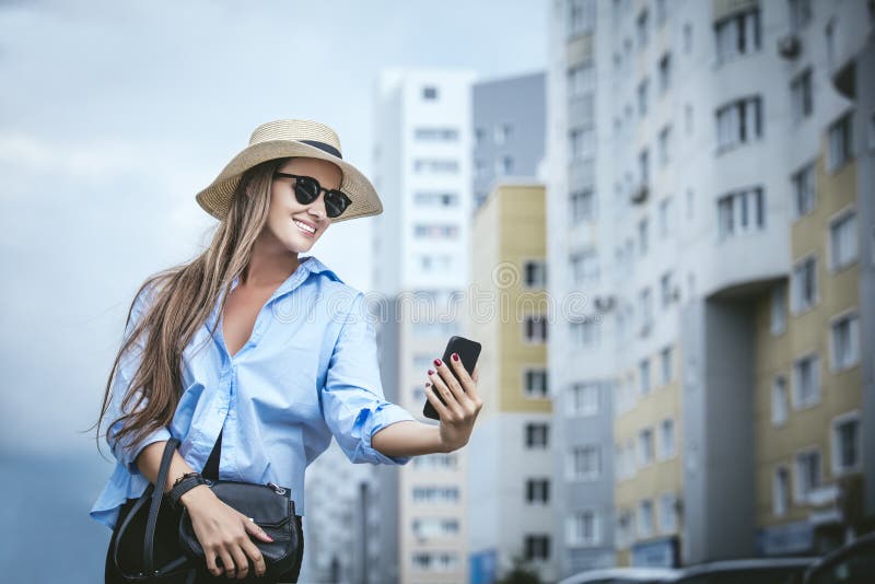 Молодые красивые рубашка и шляпа вычуры дамы модели женщины с mobi стоковые изображения rf Молодые красивые рубашка и шляпа вычуры дамы модели женщины с mobi стоковые изображения rf