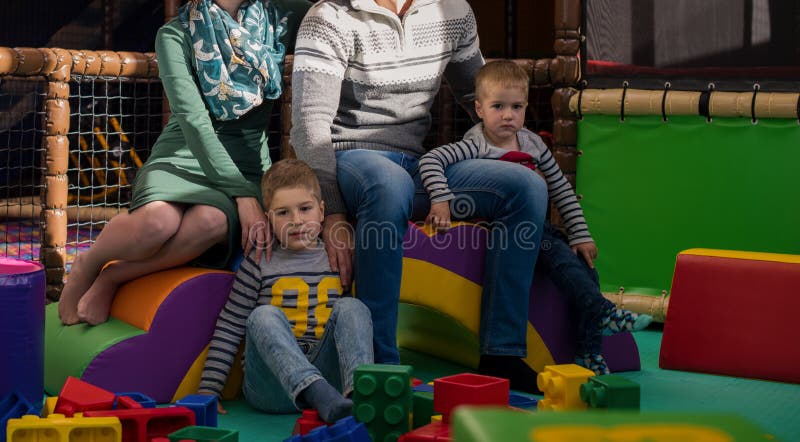 Молодые родители и дети, развлекающиеся в детской игровой комнате стоковые фотографии rf