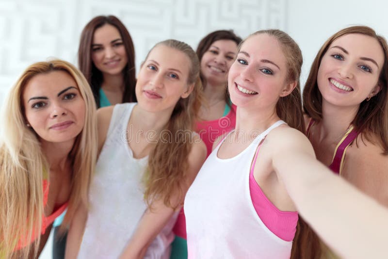 Молодые счастливые женщины одетые в sportswear принимая selfie стоковые фотографии rf Молодые счастливые женщины одетые в sportswear принимая selfie стоковые фотографии rf
