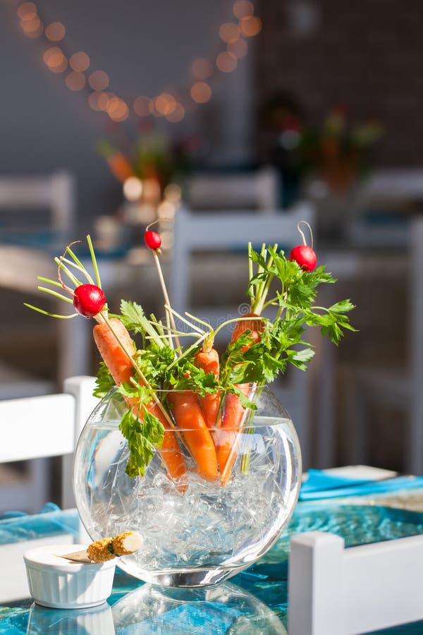 Carrot and berries ikebana decorations in a glass vase. Carrot and berries ikebana decorations in a glass vase.