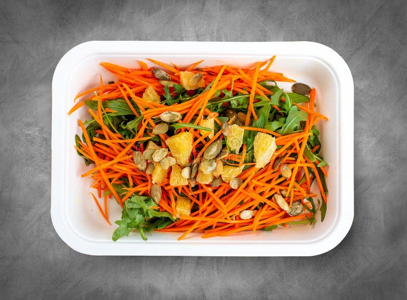 Carrot salad with orange. Healthly food. Takeaway food. Top view, on a gray background. Carrot salad with orange. Healthly food. Takeaway food. Top view, on a gray background.