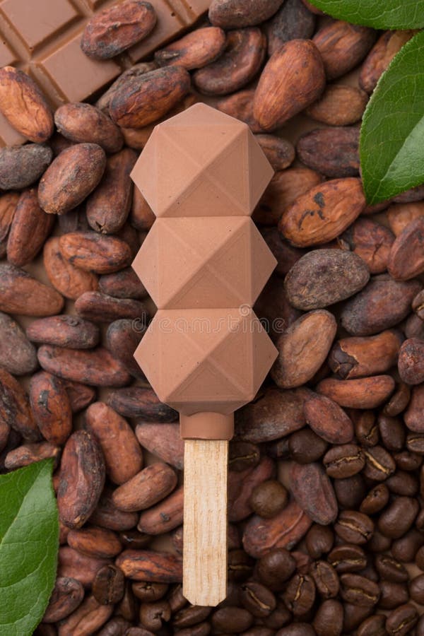 Мороженое кофе с шоколадом на предпосылке кофейных зерен и бобов кака popsicle молекулярная кухня мороженое на ручке лед стоковые фотографии rf Мороженое кофе с шоколадом на предпосылке кофейных зерен и бобов кака popsicle молекулярная кухня мороженое на ручке лед стоковые фотографии rf