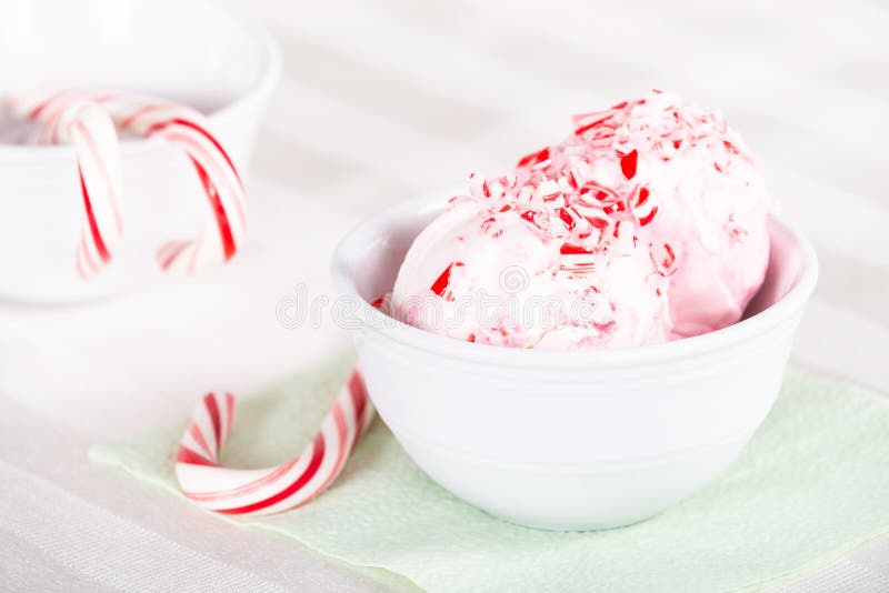 Peppermint ice cream with candy canes in a white bowl. Peppermint ice cream with candy canes in a white bowl
