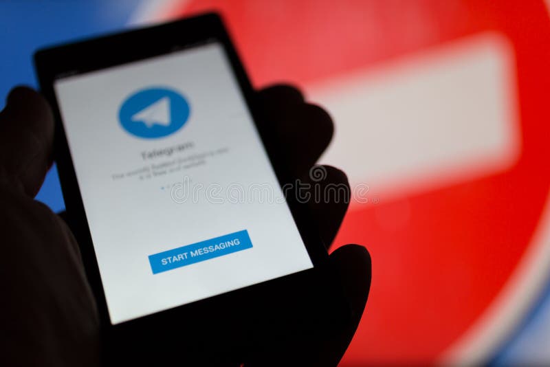МОСКВА, РОССИЯ - 16-ОЕ АПРЕЛЯ 2018: Мобильный телефон с телеграммой app в руке против запрещая знака Телеграмма запрещенная в Рос стоковое изображение rf МОСКВА, РОССИЯ - 16-ОЕ АПРЕЛЯ 2018: Мобильный телефон с телеграммой app в руке против запрещая знака Телеграмма запрещенная в Рос стоковое изображение rf