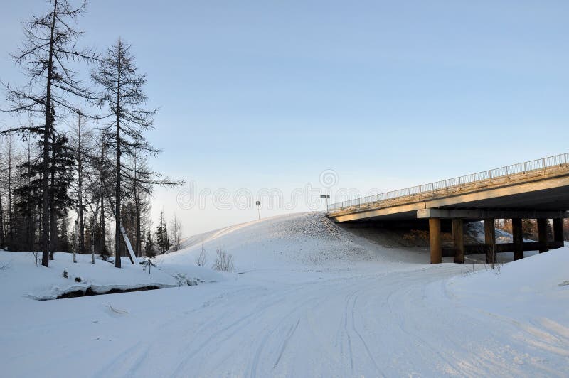 Мост зимы над морозным и снежным рекой