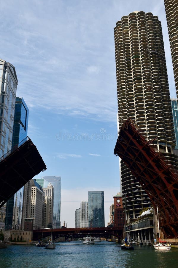 This is a Fall picture of the State Street Bridge in a raised position allowing sailboats to travel down the Chicago River, the picture features the iconic Historic Marina City located in Chicago, Illinois. The bridge built in 1949 is a metal rivet-connected Pratt Railing height truss, movable double leaf bascule. This picture was taken on October 5, 2016. This is a Fall picture of the State Street Bridge in a raised position allowing sailboats to travel down the Chicago River, the picture features the iconic Historic Marina City located in Chicago, Illinois. The bridge built in 1949 is a metal rivet-connected Pratt Railing height truss, movable double leaf bascule. This picture was taken on October 5, 2016.