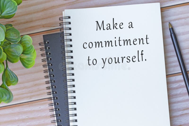 Motivational and inspirational quote on note book on wooden desk - Make a commitment to yourself. Motivational and inspirational quote on note book on wooden desk - Make a commitment to yourself.