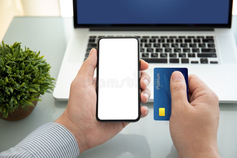 Мужские руки, занимающих отдельные телефоном кредитной карты и ноутбук экрана стоковая фотография rf