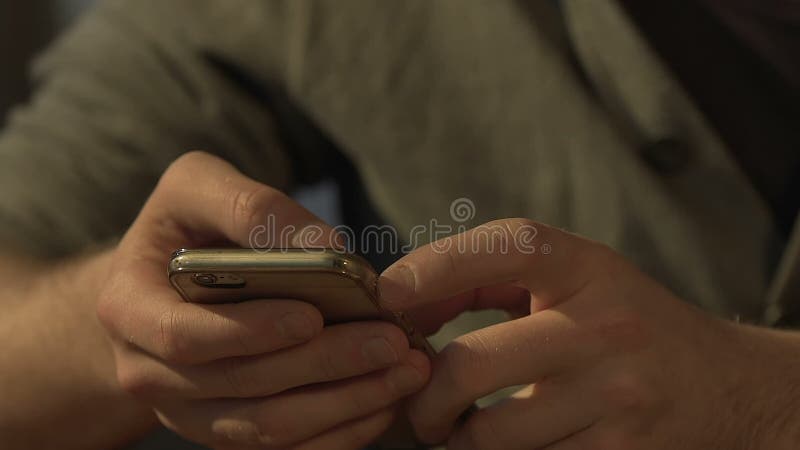 Мужские руки печатая сообщение на smartphone, социальных сетях, наркомании устройства