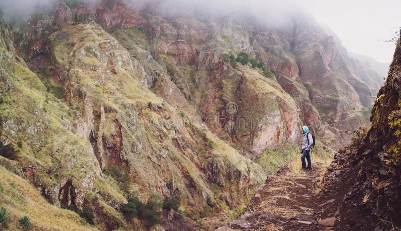 Мужской hiker на крутом скалистом пути к известной долине Пола восхищая впечатляющую сторону горы Santo Antao Кабо-Верде Cabo стоковые изображения rf Мужской hiker на крутом скалистом пути к известной долине Пола восхищая впечатляющую сторону горы Santo Antao Кабо-Верде Cabo стоковые изображения rf