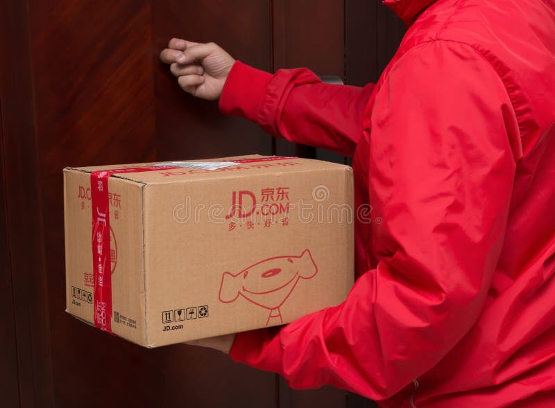 Мужской курьер от JD com поставляя пакет на онлайн дни покупок стоковые фотографии rf Мужской курьер от JD com поставляя пакет на онлайн дни покупок стоковые фотографии rf