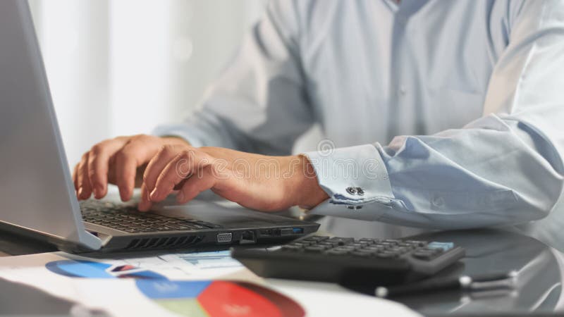 Мужской работник банка работая на ноутбуке в офисе, анализируя выгоду вклада стоковое фото rf Мужской работник банка работая на ноутбуке в офисе, анализируя выгоду вклада стоковое фото rf