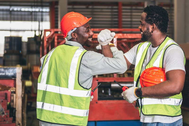 2 male worker African American, working in a factory, Shaking hands and happy that the work done together is successful, concept to teamwork of workers in industrial factories. 2 male worker African American, working in a factory, Shaking hands and happy that the work done together is successful, concept to teamwork of workers in industrial factories