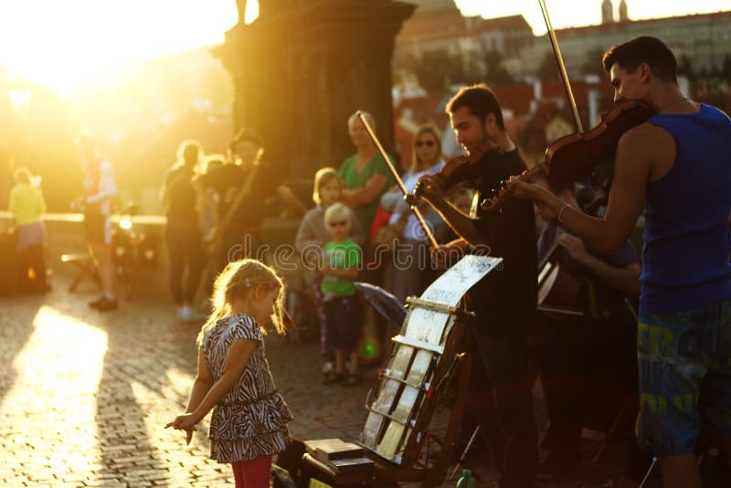 Музыканты маленькой девочки и улицы (Buskers) на Карловом мосте в Праге, чехии стоковые изображения Музыканты маленькой девочки и улицы (Buskers) на Карловом мосте в Праге, чехии стоковые изображения