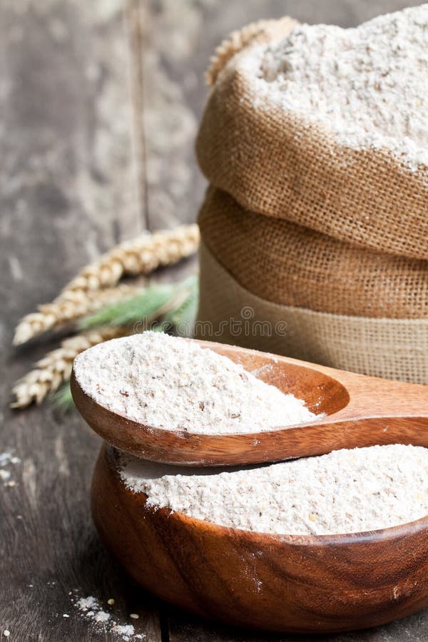Мука хлеба Wholemeal в деревянном шаре и дерюга кладут в мешки стоковое фото rf Мука хлеба Wholemeal в деревянном шаре и дерюга кладут в мешки стоковое фото rf