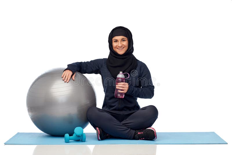 Мусульманская женщина в hijab с шариком и бутылкой фитнеса стоковые изображения Мусульманская женщина в hijab с шариком и бутылкой фитнеса стоковые изображения