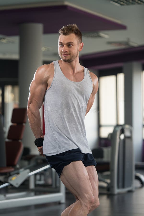 Мышечный человек изгибая мышцы в спортзале в Undershirt стоковая фотография rf